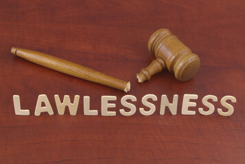 Word lawlessness and broken wooden judge gavel. Injustice and lawlessness concept.