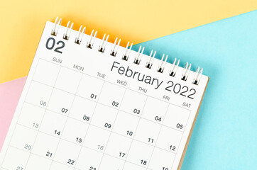 February 2022 desk calendar on multicolored background.