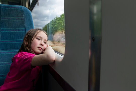 Girl (4-5)�looking through window in train