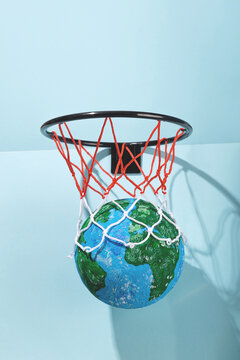 Small Earth ball in basketball hoop