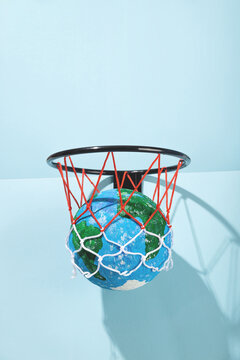 Small Earth ball in basketball hoop