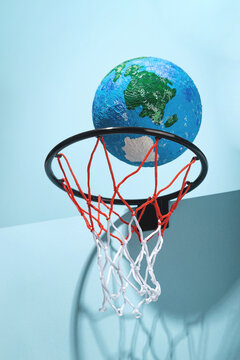 Small Earth ball in basketball hoop
