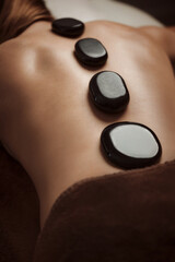 Woman getting spa treatment. Hot stone therapy. Top view