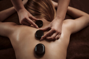 Woman getting spa treatment. Hot stone therapy. Top view
