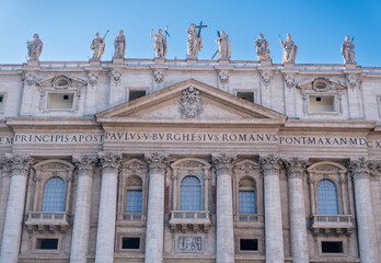 Fototapeta na wymiar Low angle view of exterior and entrance of Saint Peter's Basilica.