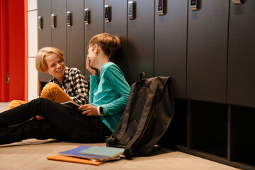 White boys laughing and using tablet computer while sitting on floor © Drobot Dean
