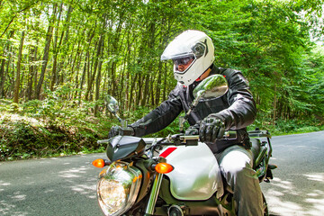 Motorcyclist riding across the forest