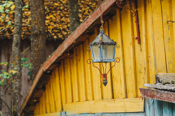 A single old lantern hanging against a garden background in the ethnographic village of Druya in Belarus