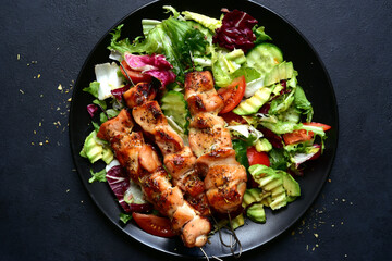 Chicken kebab skewers with fresh vegetable salad. Top view with copy space.