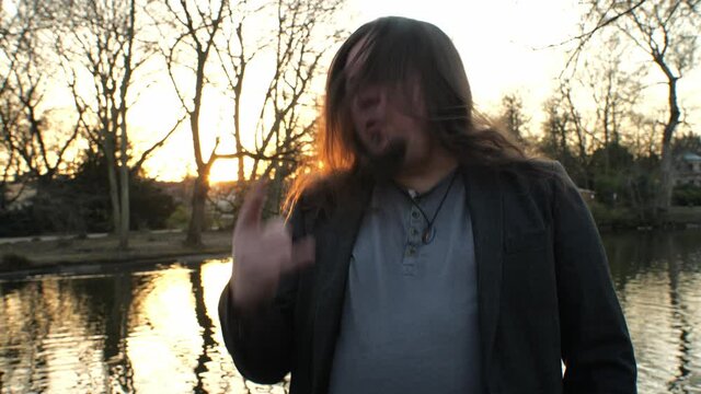 [4k] long haired hard rock fan singing in the park headbanging