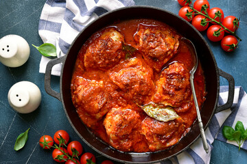 Chicken thighs stewed in tomato sauce. Top view with copy space.