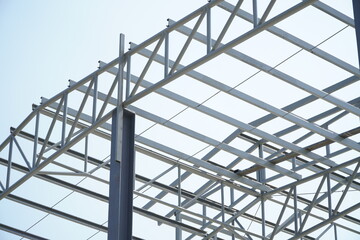 Fototapeta premium Structure of steel roof frame for building construction on sky background.