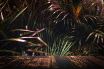 Jungle table background. Wooden table for item against the backdrop of tropical plants, palms and...