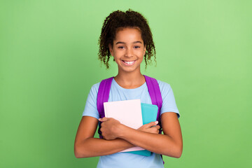 Photo of young afro girl happy smile hold boook education school lesson isolated over green color...