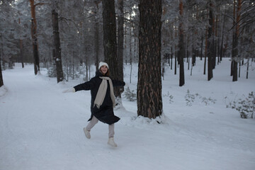 A young girl runs and rejoices in the winter.