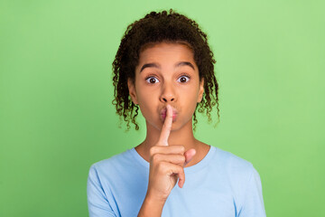 Portrait of attractive trendy girl showing shh sign keep silence isolated over green pastel color...
