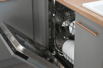 Dishwasher close-up with washed dishes, easy to use and save water, eco-friendly, built-in kitchen dish washing machine