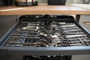 Dishwasher close-up with washed dishes, easy to use and save water, eco-friendly, built-in kitchen dish washing machine
