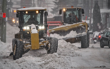 Snow removal crews cleaning city streets on a winter's day.
