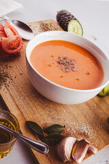 Tomato soup on wooden table, top view