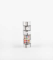 A silver metal mezuzah with colorful stones on white background.