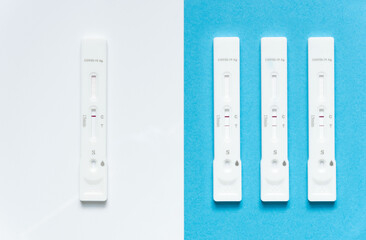 Covid-19 / SARS-CoV-2 concept antigen rapid test, Omicron variant: one with negative result on white background and three with positive result on blue background. Increase in the number of infections.