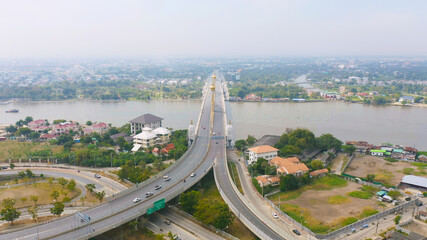 Aerial view of Maha Chesadabodindranusorn Bridge or Nonthaburi Bridge crossing Chao Phraya River and Bangkok skyline, Thailand. buildings in urban city.