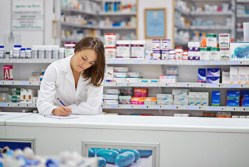 Ensuring every prescription is correct. Shot of an attractive young pharmacist working at the...
