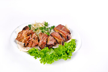 Meat kebab on ribs on lavash with onions and cabbage on a white plate, on an isolated white...