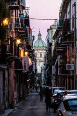 Dome of Palermo Cathedral at sunset at the end of a street, Italy