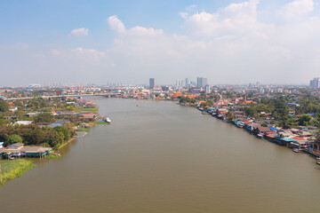 Fototapeta na wymiar Aerial top view of residential local houses with Phasi Charoen, Chao Phraya canal or river, nature trees, Nonthaburi City, Thailand in urban city town in Asia, buildings.