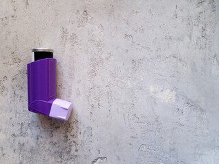 Top view of one purple inhaler on a gray neutral background. Treatment concept.