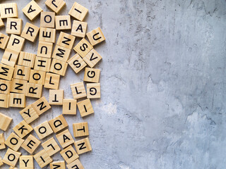 Top view of the letters of the alphabet on a gray background. Part of the surface is empty. Copy space.