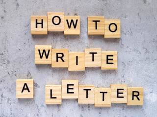 Top view of words HOW TO WRITE A LETTER made from wooden letters. The concept of writing skills.