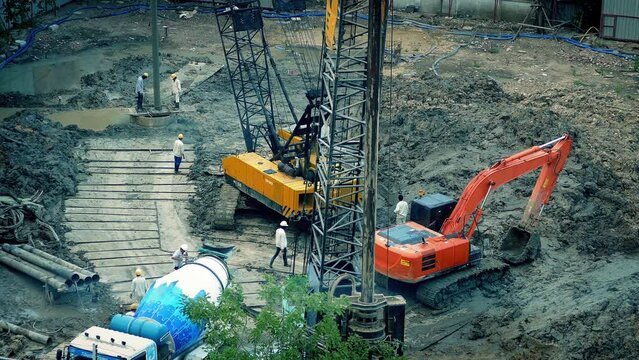 Workers And Excavators On Construction Site
