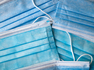 Many new blue medical face masks. Abstract background.