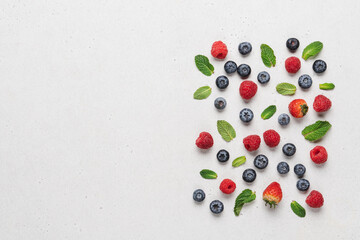 Variety of neatly arranged berries of raspberries, blueberries, strawberries on white background top view