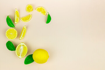 Fresh organic yellow lemon lime fruit with slice and green leaves isolated on pastel background. Flat lay, top view, copy space