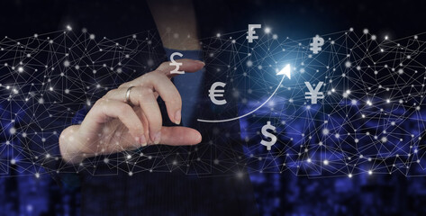 Global currency exchange concept Hand hold digital hologram virtual currency, financial sign on city dark blurred background. Business ideas, currency exchange, and global stock market analysis.
