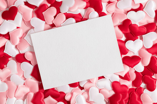 Valentine's Day background. White postcard mockup on background of pink and white hearts. Saint Valentine. Flat lay, top view, copy space