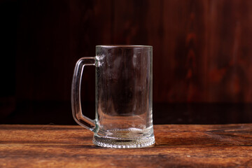 Empty glass for beer on a wooden background. Dirty beer glass.