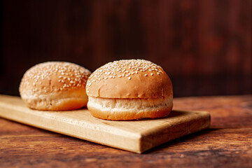 Hamburger buns. Sesame seeds on top. Wooden background. Food concept.