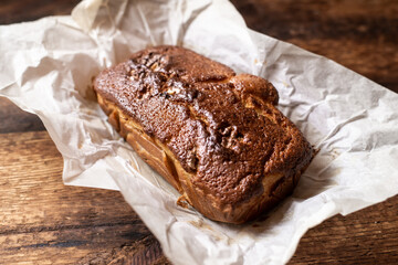 Baked banana bread. Dark wooden background. A whole freshly made loaf of bread.