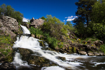 Fototapeta na wymiar Waterfall on a warm clear sunny summer day