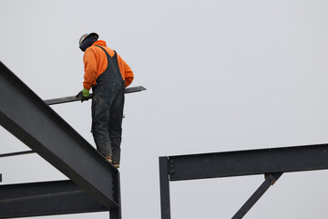 Construction workers walk on narrow beams