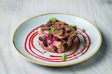 Napoleon dessert with blueberries on plate on grey table