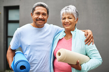 Get fit, stay fit. Portrait of a happy older couple carrying their exercise mats outdoors.