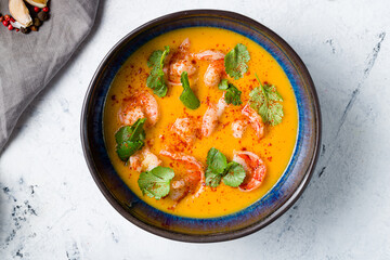 Tom Yam soup with shrimps on blue bowl on grey table top view