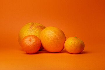 citrus on an orange background. Orange, tangerine, grapefruit on an orange background