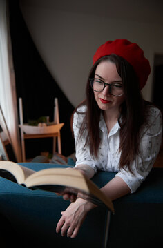 a girl with dark long hair in a red beret and a white blouse, retro style. Indoor soft light